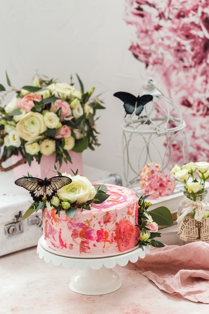 Rosa Kuchen verziert mit Blumen und echten Schmetterlingen stieg romantische Atmosphäre