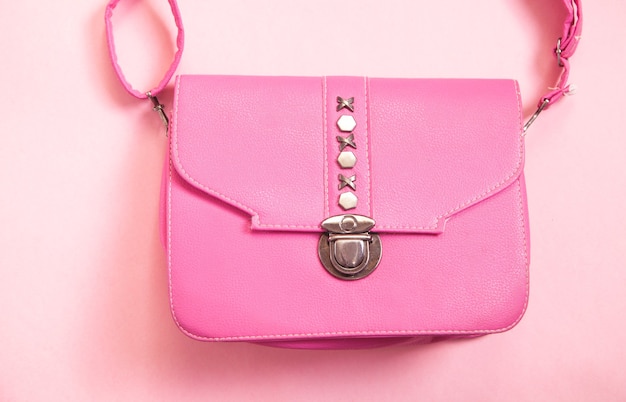 Rosa Lederhandtasche auf rosa Hintergrund.