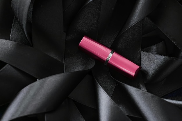 Rosa Lippenstift auf schwarzem Seidenhintergrund Luxus-Make-up und Schönheitskosmetik
