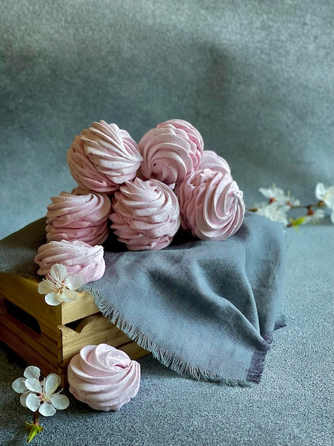 rosa marshmallow auf grauem hintergrund, ein schöner marshmallow auf einer kleinen holzkiste