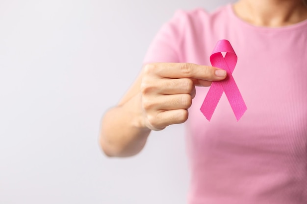 Rosa mes de concientización sobre el cáncer de mama de octubre mujer mano sujetar cinta rosa y usar camisa para apoyar la vida y la enfermedad de las personas Mes nacional de sobrevivientes de cáncer Concepto del día de la madre y el cáncer mundial