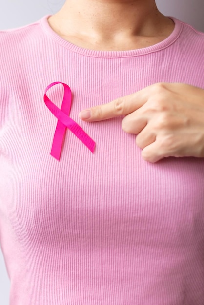 Rosa mes de concientización sobre el cáncer de mama de octubre mujer mano sujetar cinta rosa y usar camisa para apoyar la vida y la enfermedad de las personas Mes nacional de sobrevivientes de cáncer Concepto del día de la madre y el cáncer mundial