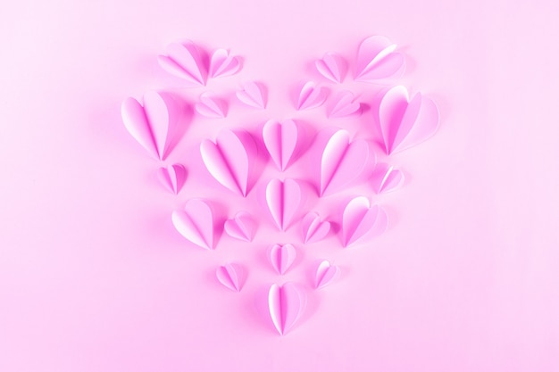 Rosa Papier in Form des Herzens auf Pastellrosahintergrund. Valentinstag