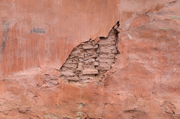 Rosa Putz an der Wand eines alten zerfallenden Hauses. Hintergrund und Textur der Altstadt