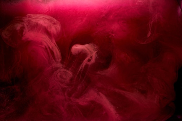 Rosa Rauch auf schwarzem Tintenhintergrund, bunter Nebel, abstrakte wirbelnde Berührung des Ozeans, Acrylfarbenpigment unter Wasser