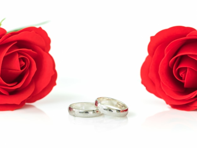 Rosa roja y anillo de bodas en blanco