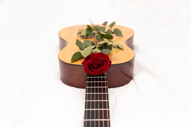 Una rosa roja en una guitarra clásica.