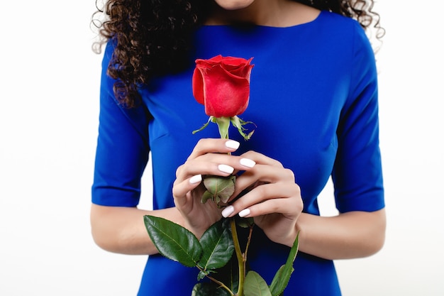 Rosa roja en manos de mujer negra con vestido azul