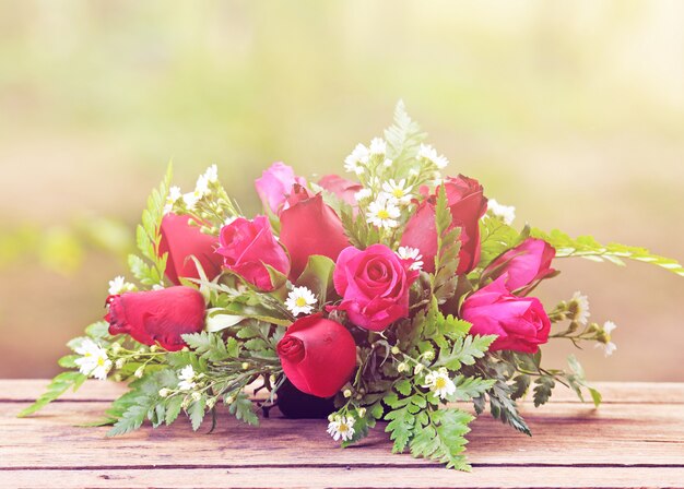 Rosa roja en una mesa de madera