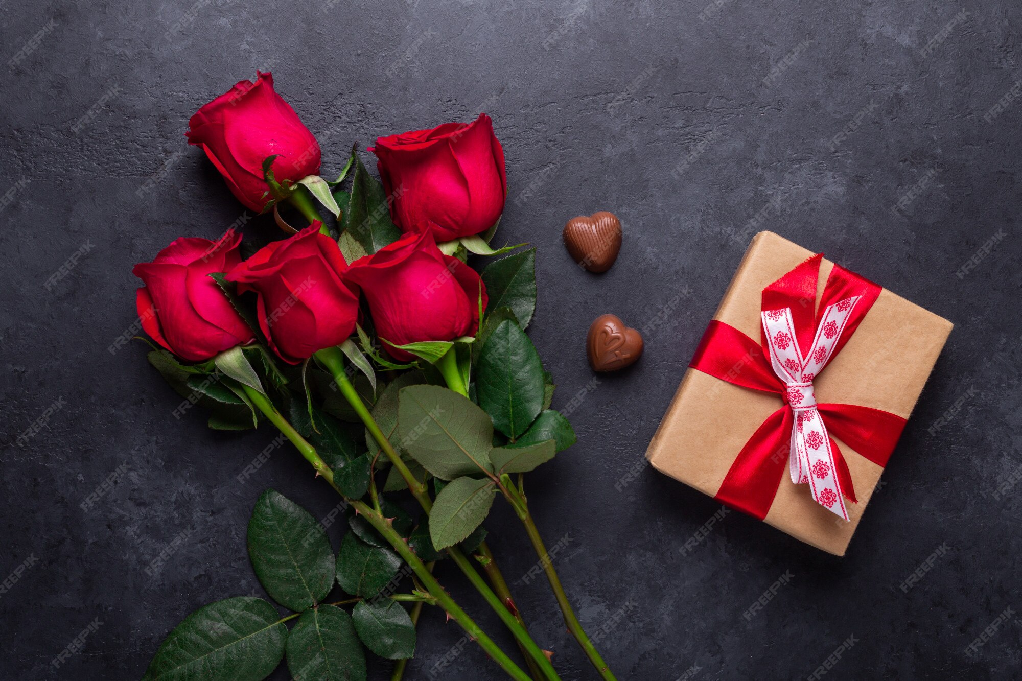 Rosa roja ramo de flores, caja de regalo, dulces de chocolate en piedra  negra. tarjeta de felicitación del día de san valentín | Foto Premium