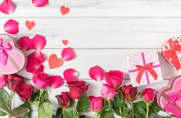 Foto rosa roja y rosa con caja de regalo en el fondo blanco de madera, el amor y el concepto de san valentín