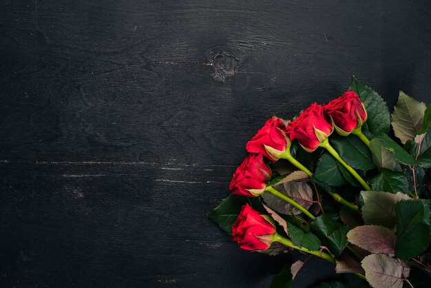 Rosa roja sobre un fondo de madera. Día de San Valentín. Amor. Vista superior. Espacio libre para su texto.