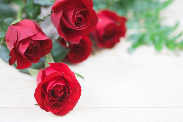 Rosa roja sobre fondo de madera con espacio de copia.