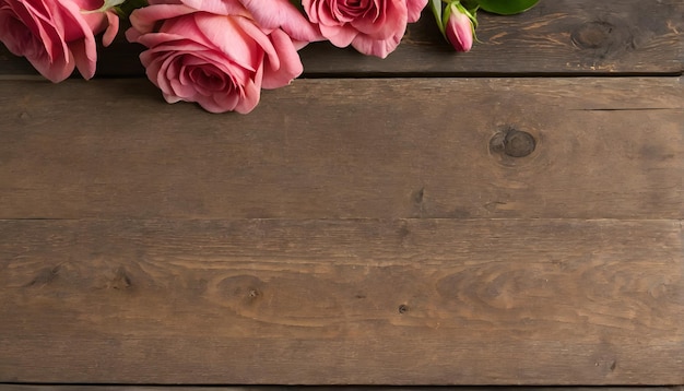 una rosa rosada está en una mesa de madera