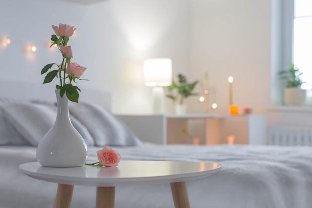 Rosa Rosen in der Vase auf dem Tisch im Schlafzimmer