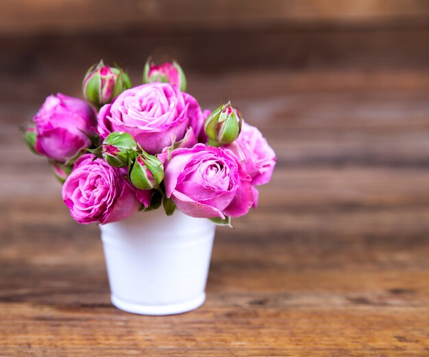 Rosa Rosen in einer Vase auf Holzoberfläche