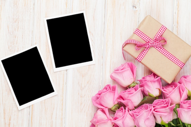 Foto rosa rosen und valentinstag geschenkbox und zwei leere fotorahmen