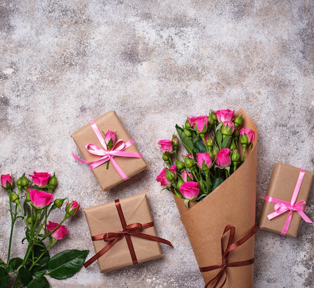 Rosa Rosenblumenstrauß und Geschenkboxen