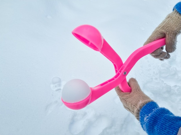 Rosa Schneeballmacher macht Bälle aus Schnee