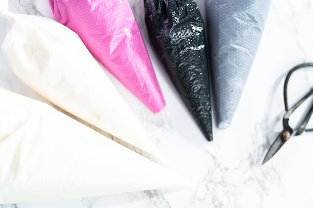 Rosa, schwarze und weiße königliche Glasur in Spritzbeuteln.