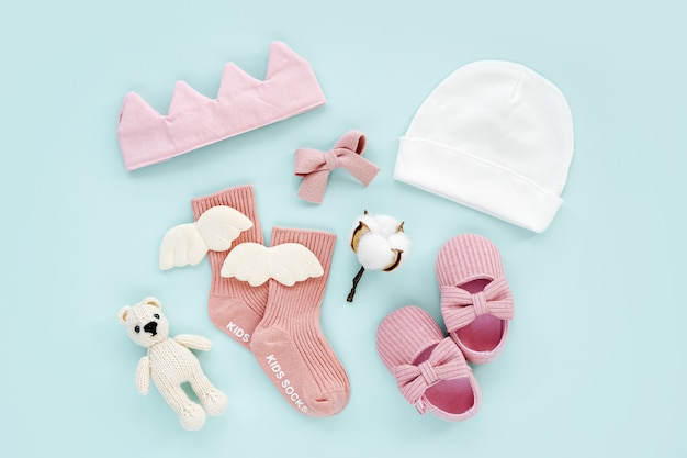 Foto rosa socken, spielzeug und süße babyschuhe für mädchen. set neugeborene kleidung und accessoires. flache lage, ansicht von oben