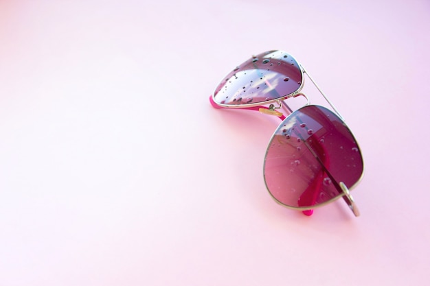 Rosa Sonnenbrille auf einem rosa Hintergrund, mit Reflexionen, Minimalist, Kopienraum.