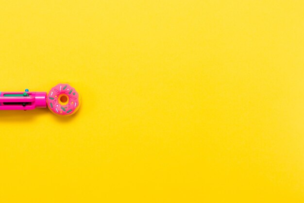 Rosa Stift in Form eines Donuts isoliert auf gelbem Hintergrund Mehrfarbiger Stift Zurück zur Schule