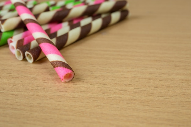 Rosa Streifenwafer der Nahaufnahme rollt auf Tabelle.