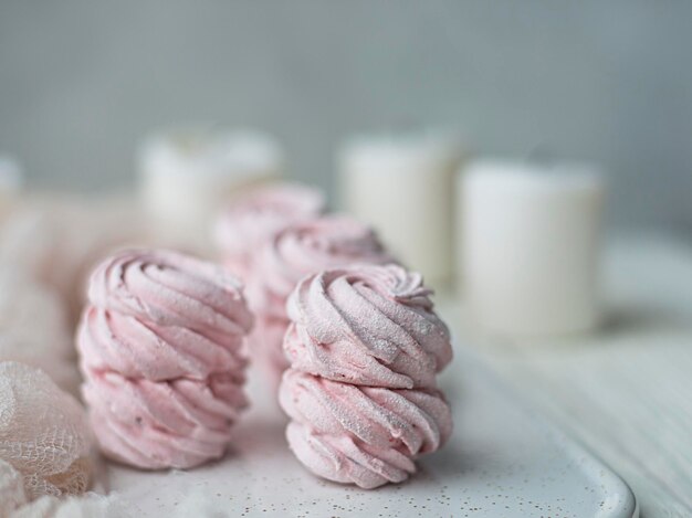 Rosa süße Baiser-Zephyr-Marshmallows auf hellem Hintergrund