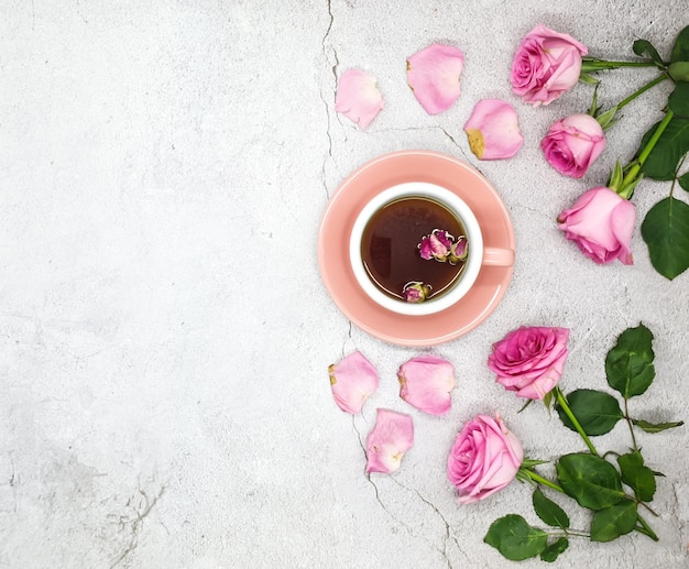 Rosa Tasse Tee mit Rosen auf weißem Hintergrund