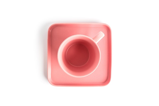 Rosa Teetasse und Untertasse für das Getränk lokalisiert auf weißem Hintergrund. Kaffeetasse oder Becher aus Keramik aus nächster Nähe. Foto in hoher Qualität