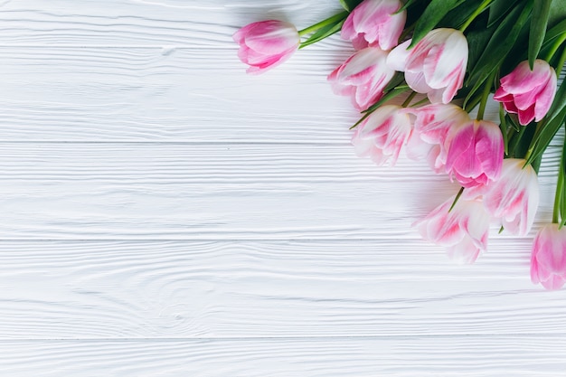 Rosa Tulpen auf einem weißen hölzernen Hintergrund. Draufsicht und Wohnung zu legen.
