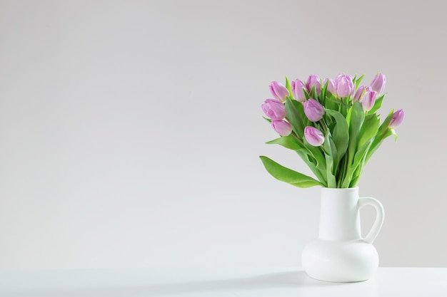 rosa Tulpen in einem weißen Krug auf weißem Hintergrund