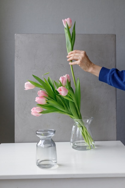 Rosa Tulpen mit grünen Blättern in einer Glasvase