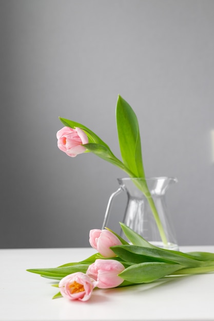 Rosa Tulpen mit grünen Blättern in einer Glasvase