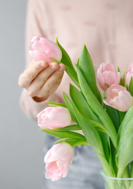 Rosa Tulpen mit grünen Blättern in einer Glasvase