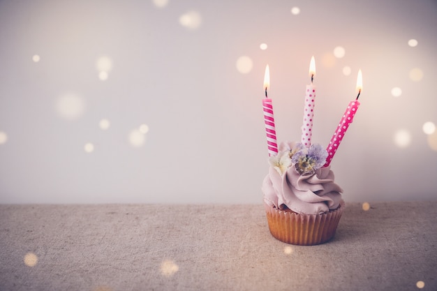 Rosa und lila Geburtstag Cupcake mit drei Kerzen