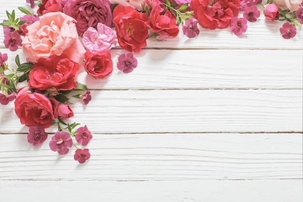 Foto rosa und rote rosen auf weißem hölzernem hintergrund