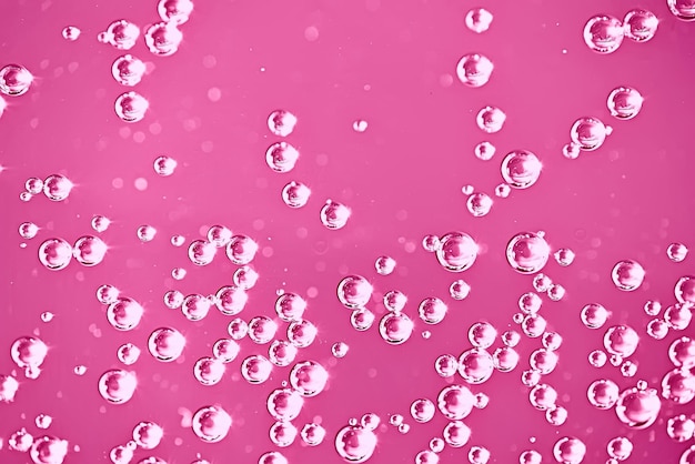 Foto rosa wasser sprudelt hintergrund / frischer sommerhintergrund rosa luftblasen im wasser