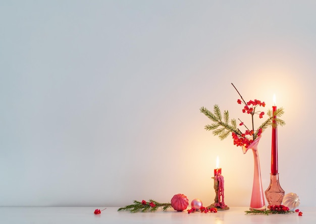 Rosa Weihnachtsdekor mit brennenden Kerzen im weißen Innenraum