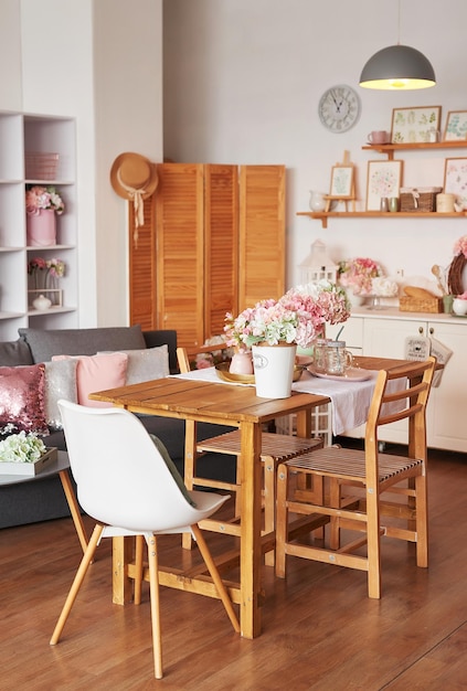 Rosa Wohnzimmer und Küche. Atelierwohnung. Loft-Interieur. Regale und Frühlingsdekor im Zimmer. Miete und Lieferung von Wohnungen. Herberge und Hotel.