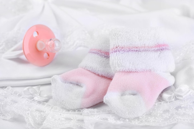 Rosafarbene Babysocken auf Stoffnahaufnahme