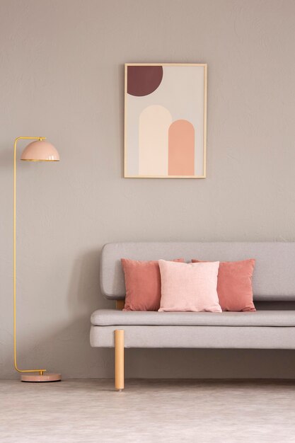 Foto rosafarbene lampe neben grauer couch mit kissen im wohnzimmerinterieur