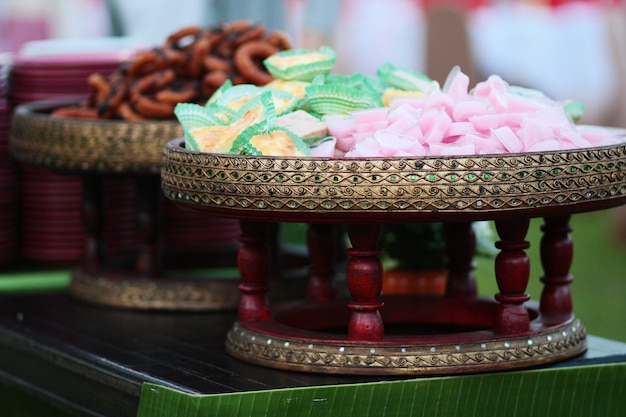 Rosafarbenes Gelee der thailändischen süßen Nachtische im Herzen formte und Bananenkleiner kuchen auf Rattankorb im Hochzeitsgarten
