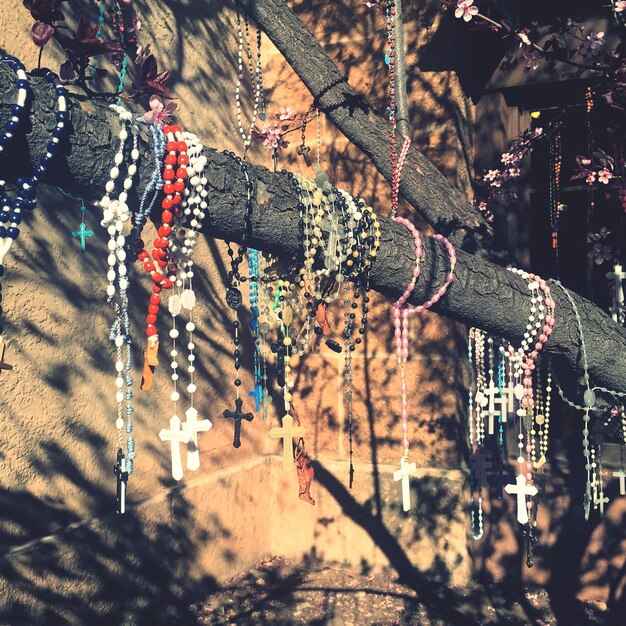 Foto rosario colgando en el árbol contra la pared