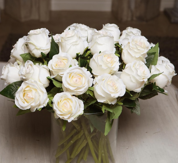 Rosas blancas en una decoración de jarrón de vidrio.