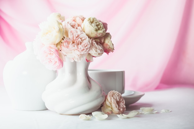 Rosas blancas y rosadas en un jarrón sobre la mesa