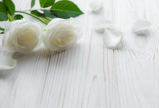 Rosas blancas sobre una mesa de madera.