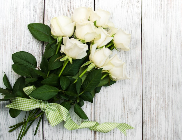 Rosas blancas sobre una mesa de madera.