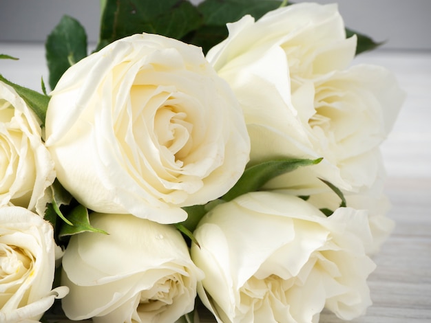 Rosas brancas em uma mesa de madeira branca